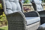 Grey rattan garden chair with padded seat and backrest in outdoor setting