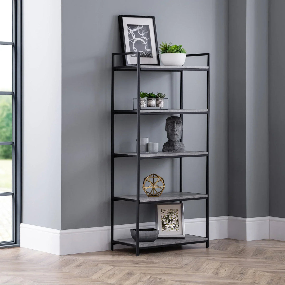 Tall black metal bookcase with grey shelves styled in modern living room corner