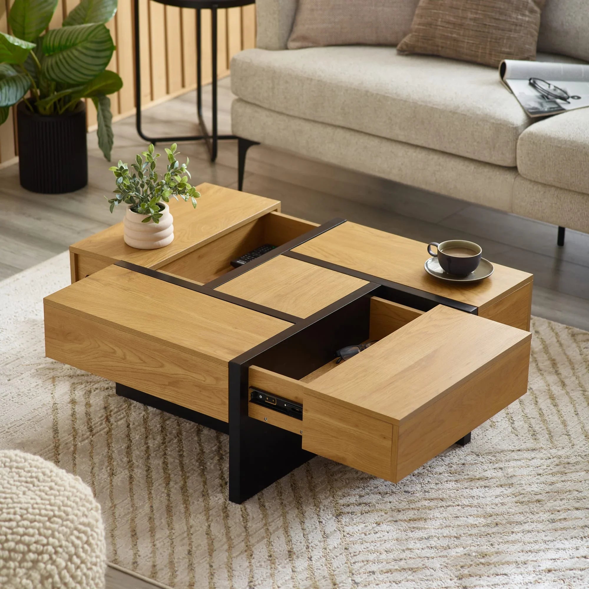 Oak coffee table with black accents and open drawers in modern living room setting