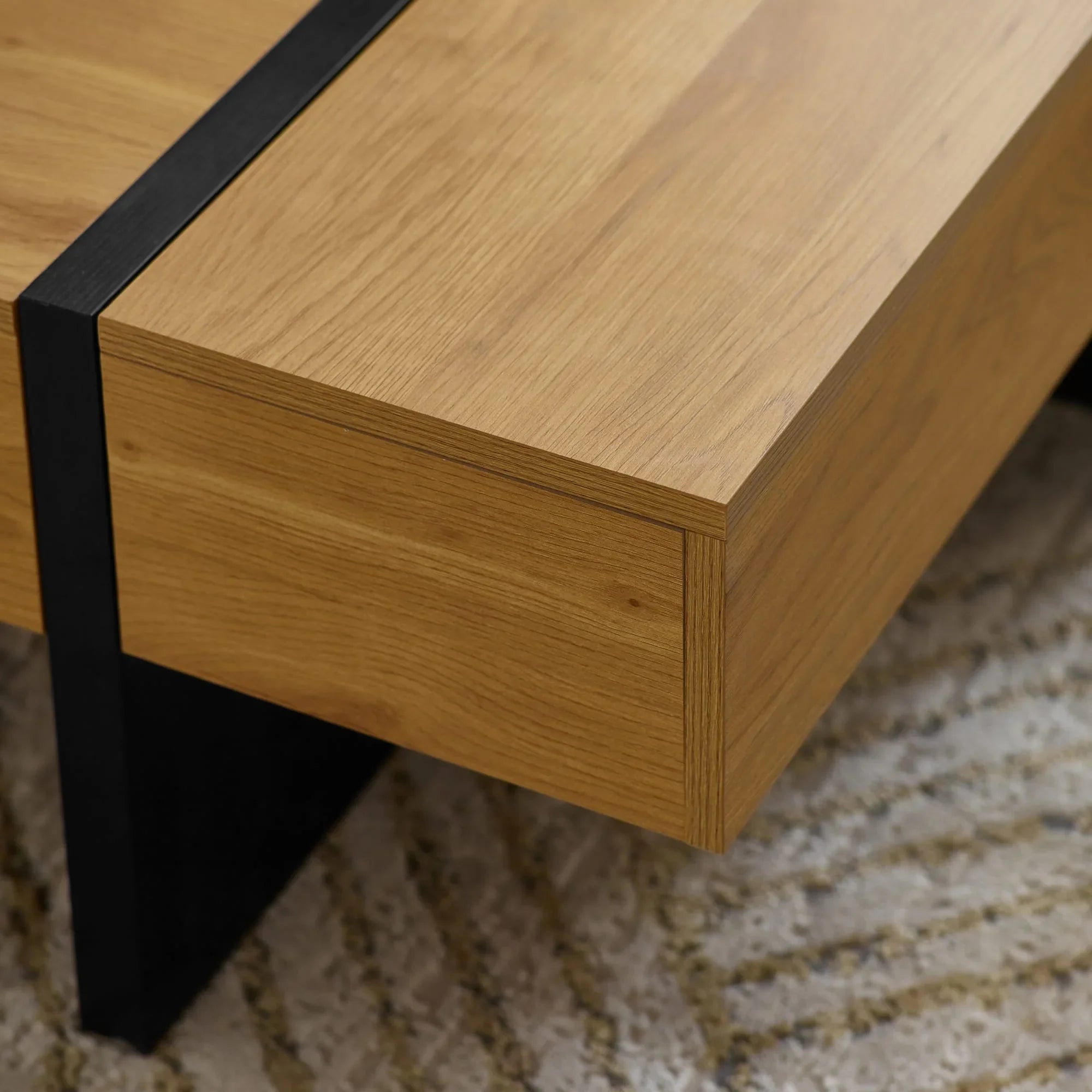 Oak coffee table corner with black metal leg on textured rug