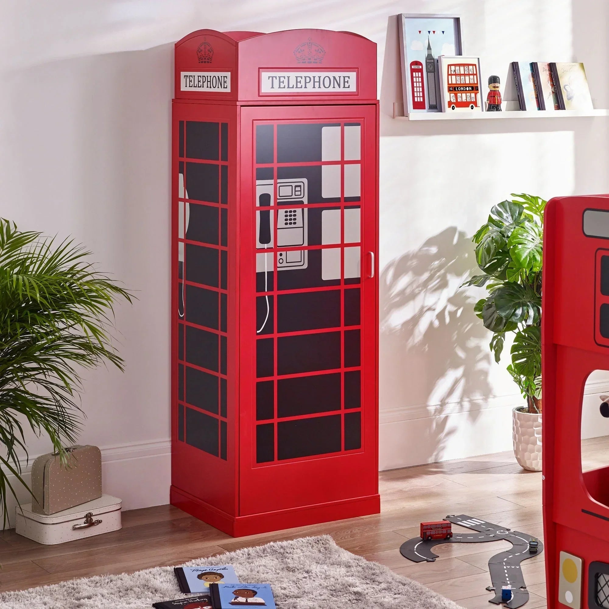 Red telephone box wardrobe in kids bedroom with books and play mat