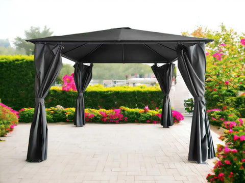 Black outdoor gazebo with curtains on patio surrounded by garden flowers and greenery