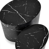 Close-up top view of two black oval nest tables with white marble veining on white background