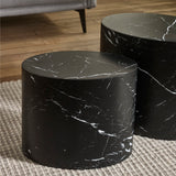 Small and large black oval tables with white marble veins on beige rug in living room setting