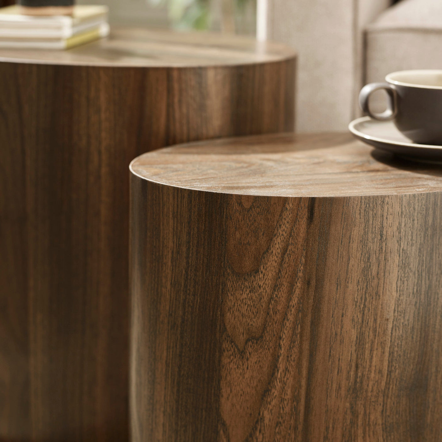 Close-up showing smooth curved edge and wood grain detail of dark wood oval nest tables