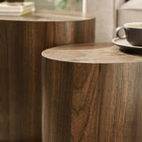 Close-up showing smooth curved edge and wood grain detail of dark wood oval nest tables