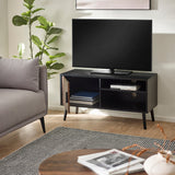 Small black wood TV unit with walnut door open showing shelves and books, next to gray sofa in living room