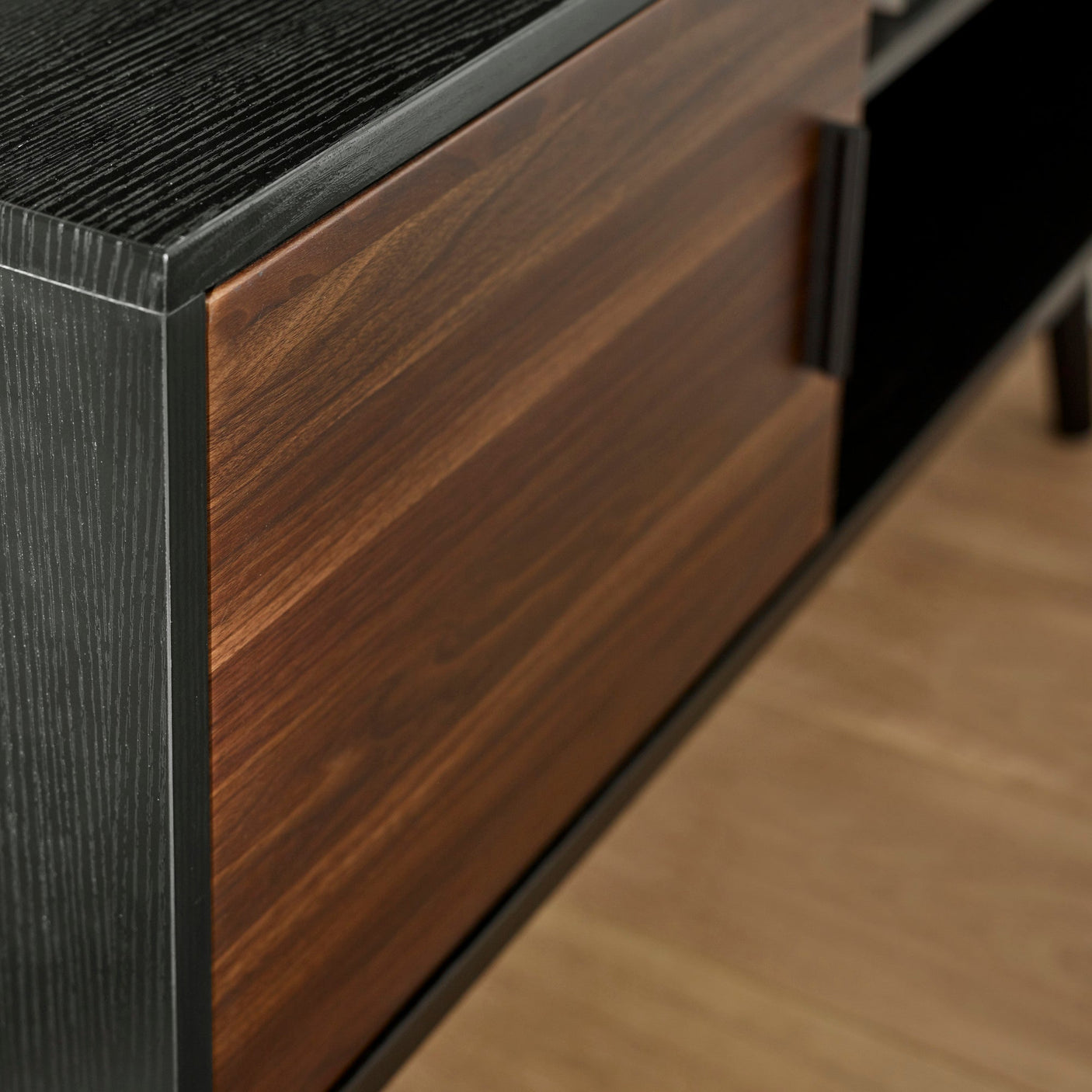 Close up of walnut wood grain door and black wood frame of the small TV unit