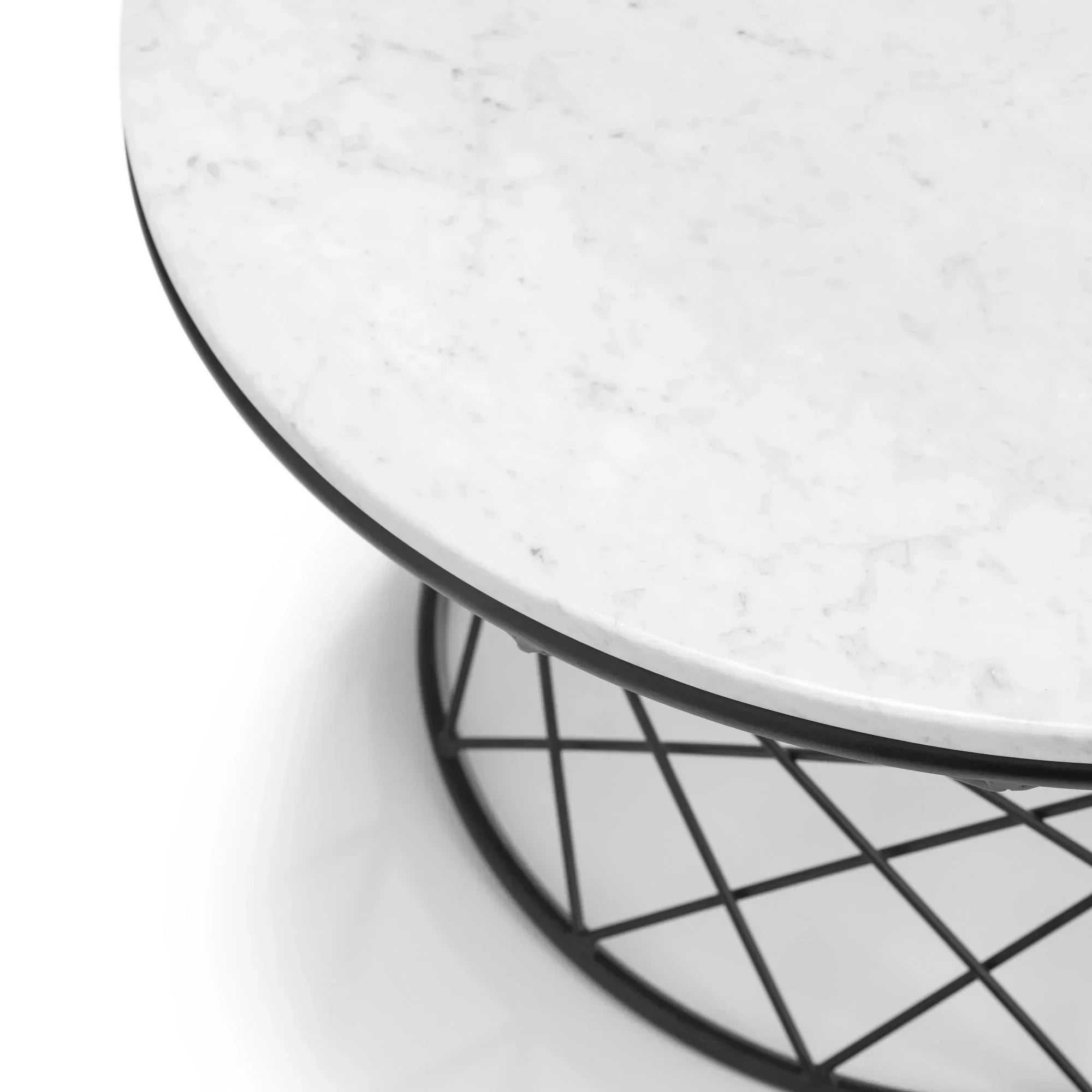 Round marble coffee table with black metal geometric base, close-up of tabletop and edge