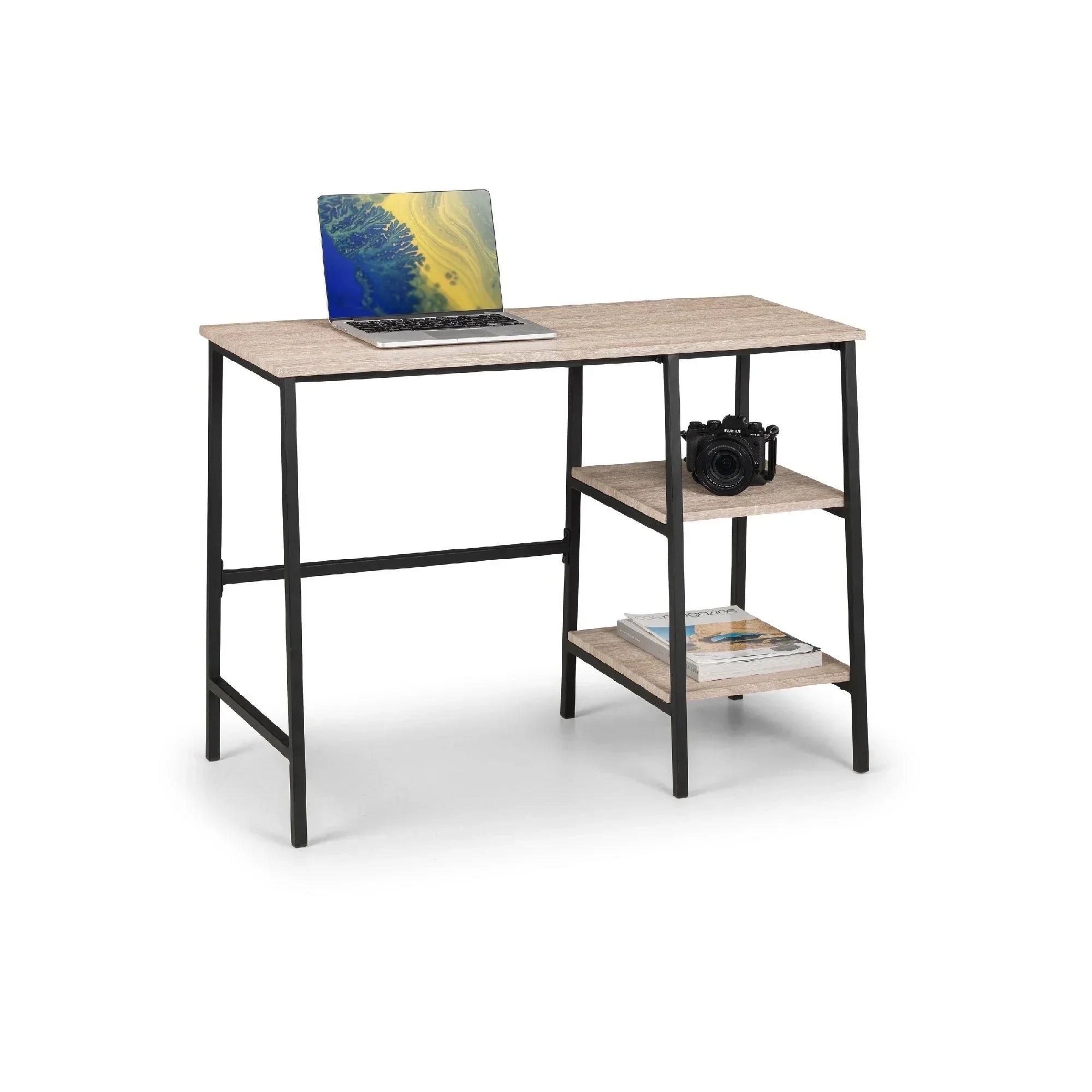 Sonoma oak computer desk with black frame, open shelving, laptop, camera, and magazines