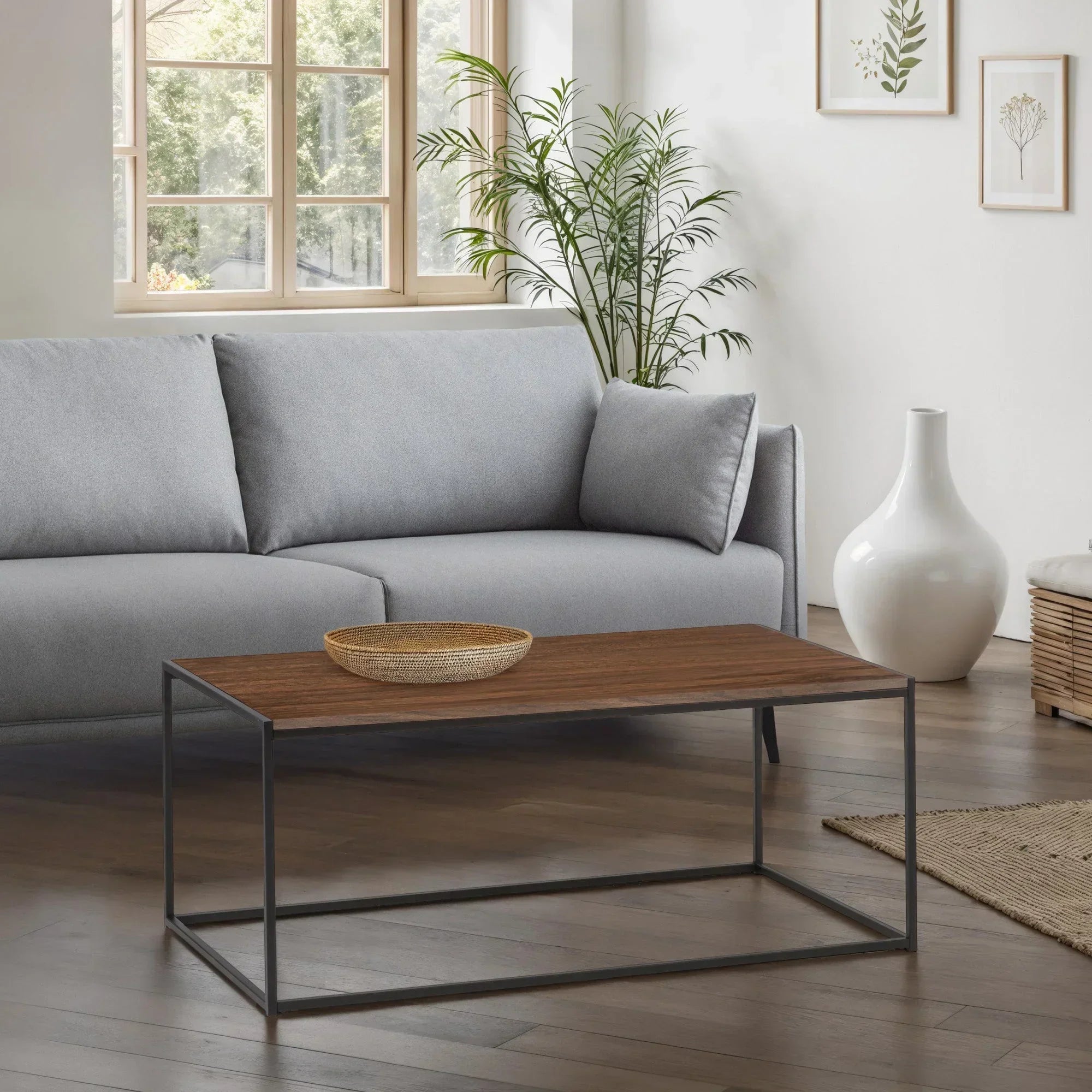 Modern rectangular wood coffee table with metal frame in living room with grey fabric sofa