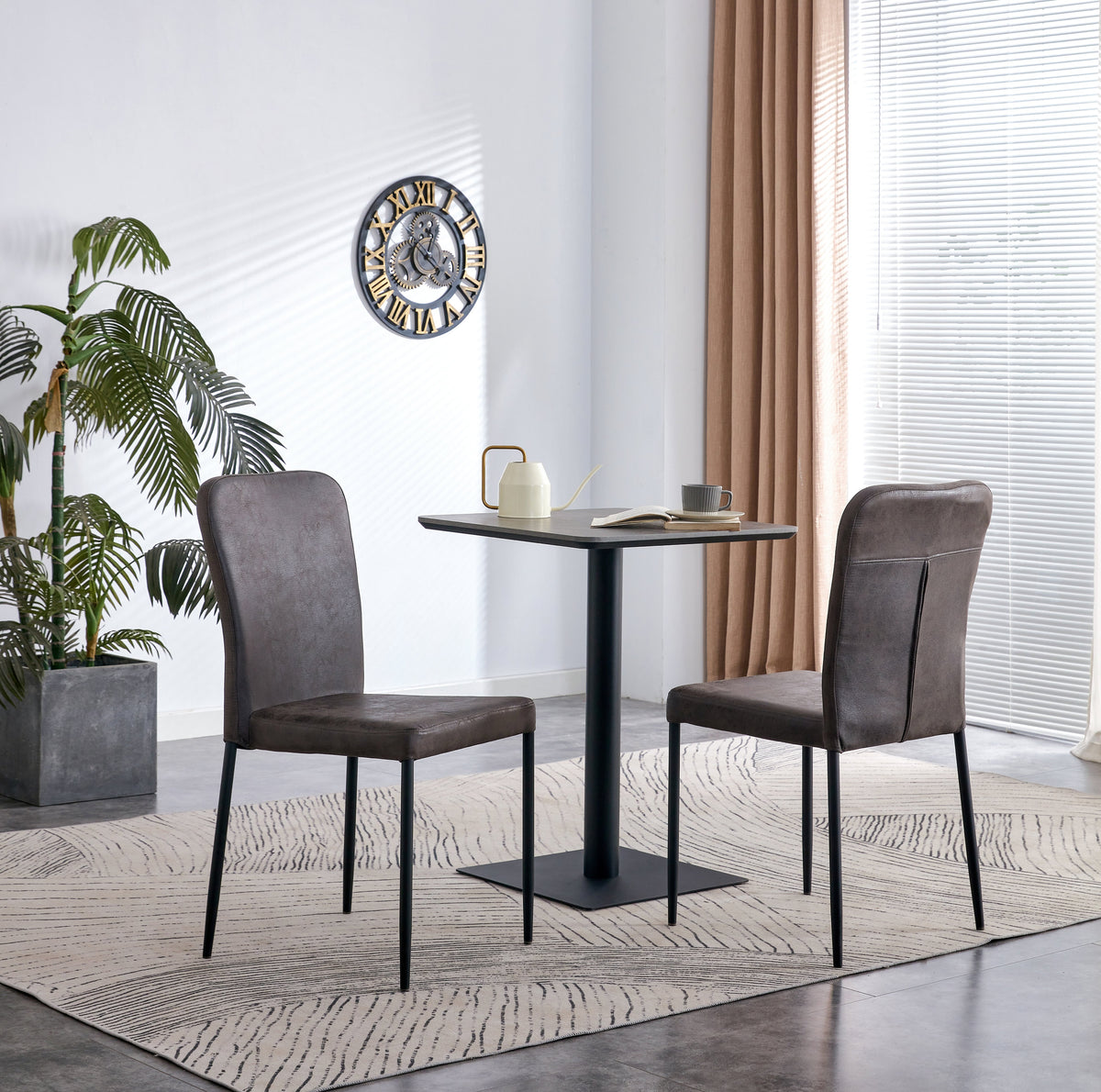 Grey upholstered dining chairs with black pedestal dining table in a bright modern dining room.