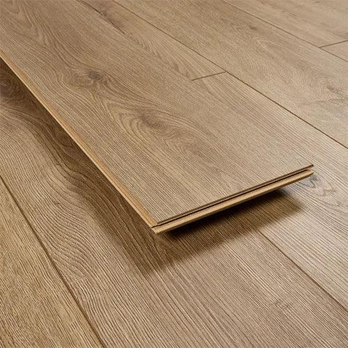 Tawny oak laminate flooring plank with wood grain texture on matching floor surface