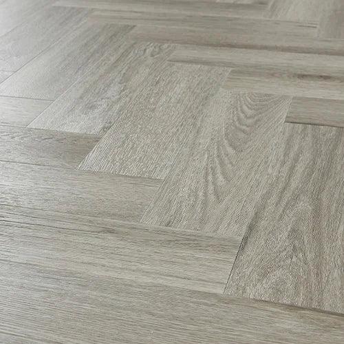 Urban grey laminate flooring in herringbone pattern with wood grain texture