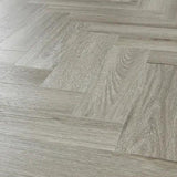 Urban grey laminate flooring in herringbone pattern with wood grain texture