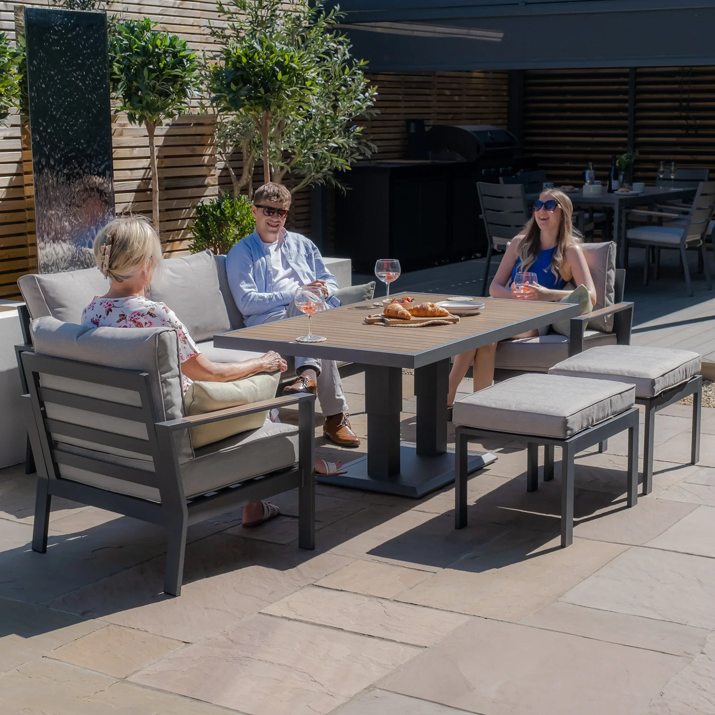 Modern outdoor garden furniture set with grey cushioned seating and rectangular dining table