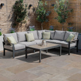 Grey outdoor corner sofa set with cushions and rectangular coffee table on patio