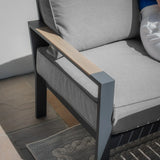 Grey outdoor sofa chair with metal frame, light wood armrest, and thick cushioned seat