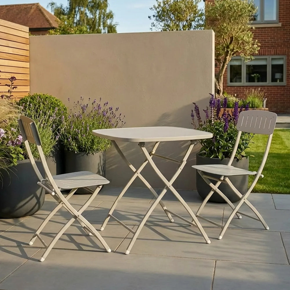 Folding patio bistro set with two chairs and round table on a stone terrace
