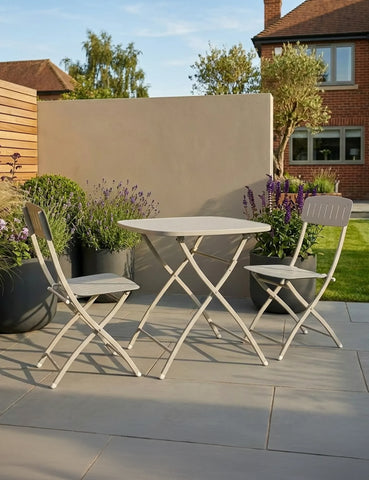 Folding patio bistro set with two chairs and round table on a stone terrace