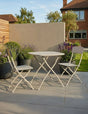 Folding patio bistro set with two chairs and round table on a stone terrace