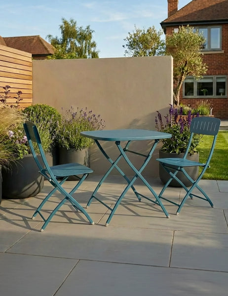 Blue metal bistro set with round table and two chairs on patio surrounded by potted plants