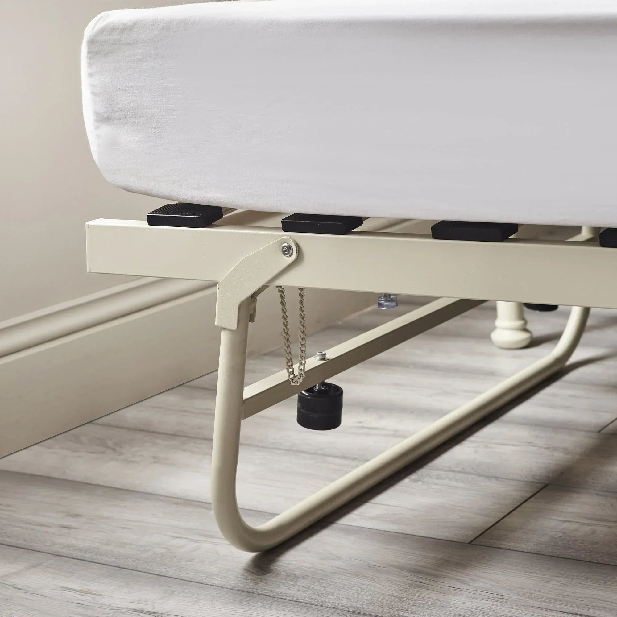 Stone white metal daybed frame detail with slats and leg support on wooden flooring