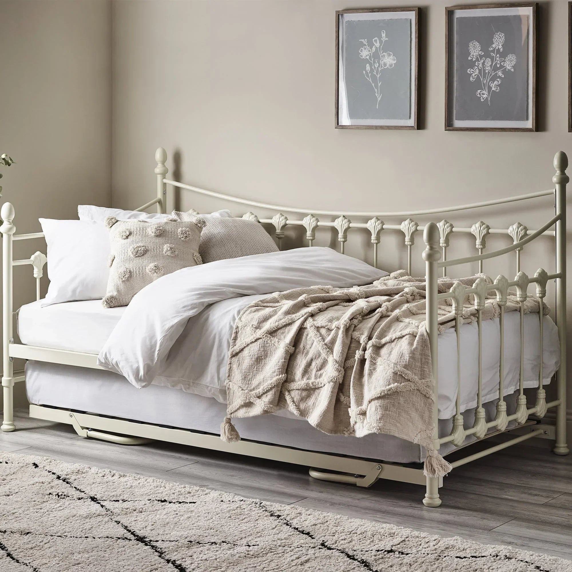 Stone white metal daybed with trundle, styled with neutral bedding and cushions in a modern room