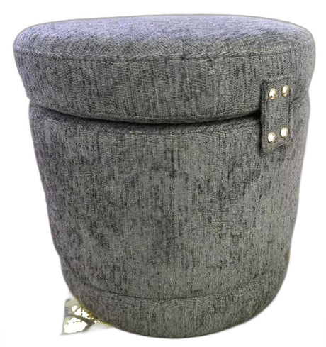 A round, upholstered storage ottoman or stool with a textured gray fabric cover, featuring a small side tab with gold-tone metal studs and a small gold tag near the base, shown on a plain white background.