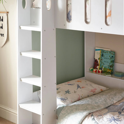 White bunk bed with built-in shelves and dinosaur print bedding in a child’s room