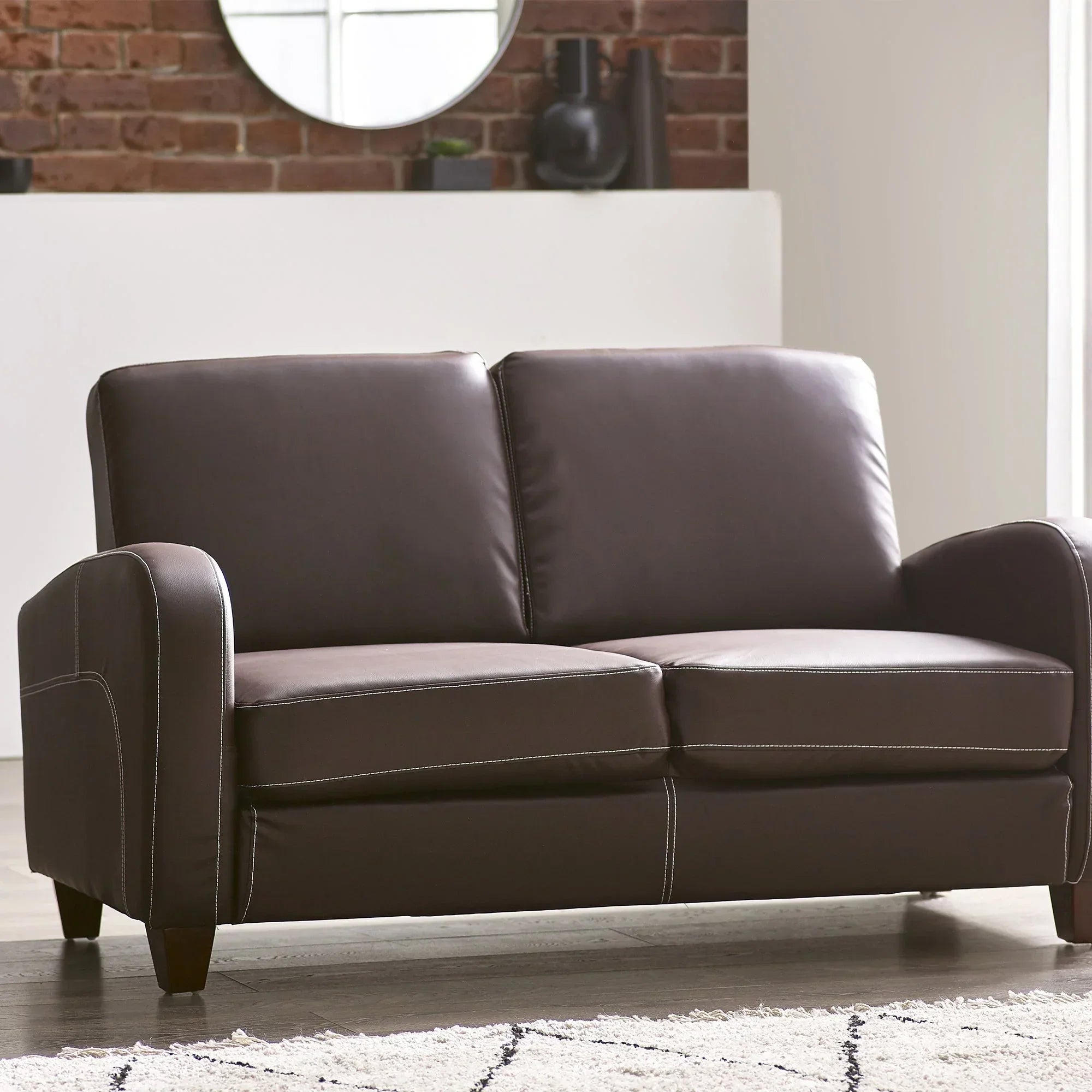 Brown leather 2 seater sofa with white stitching in modern living room setting