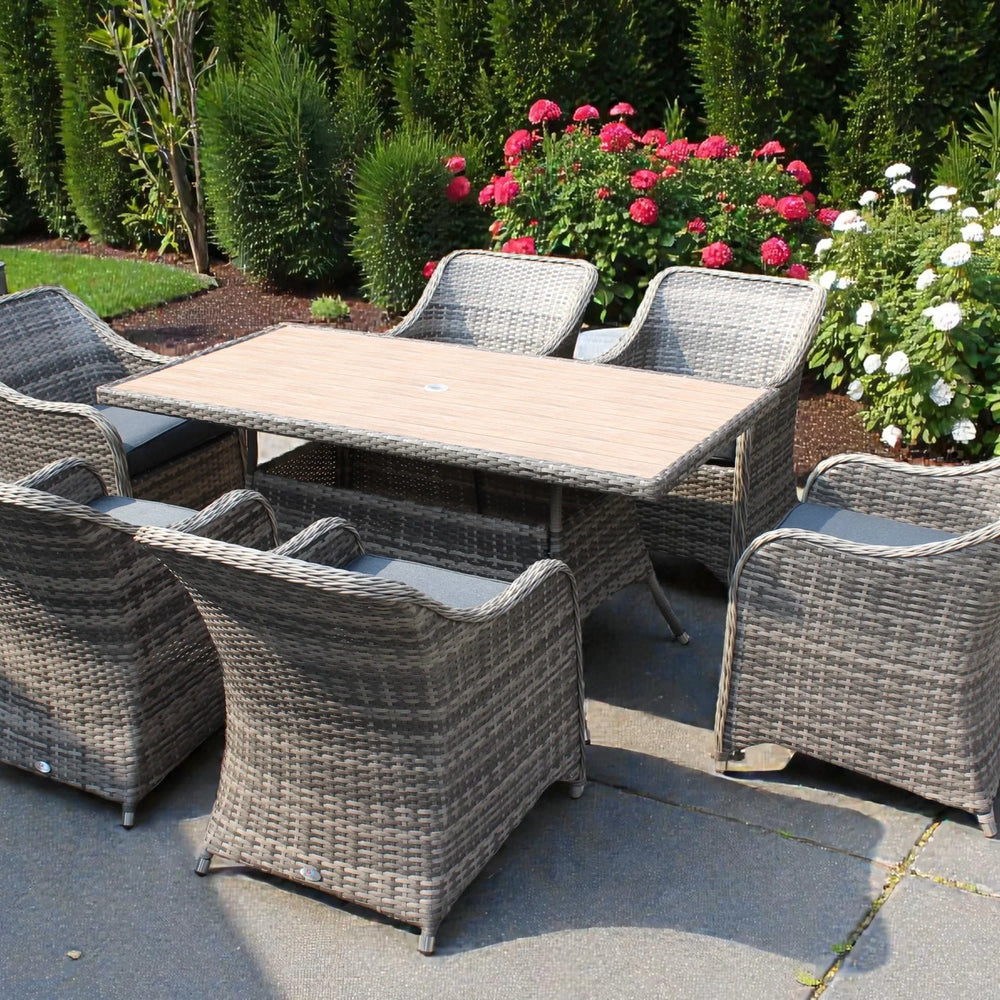 Rattan garden dining set with six cushioned chairs and rectangular table on patio