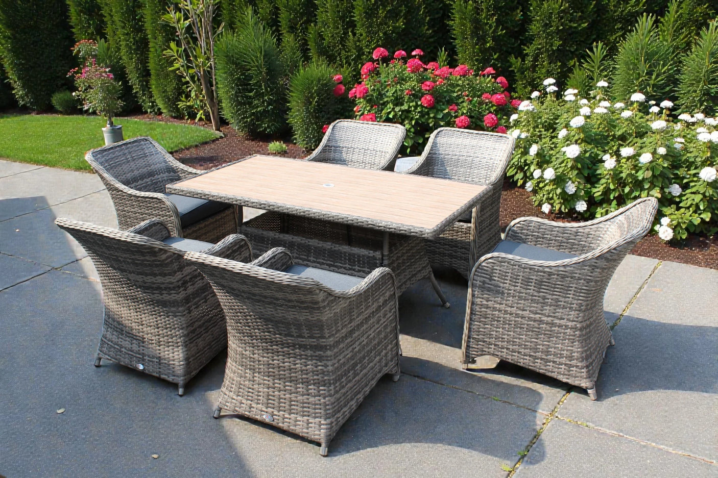 Rattan garden dining set with six cushioned chairs and rectangular table on patio
