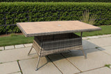 Rectangular rattan garden table with wood-effect top on stone patio