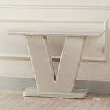 Cream console table with V-shaped base against wall on light wood floor