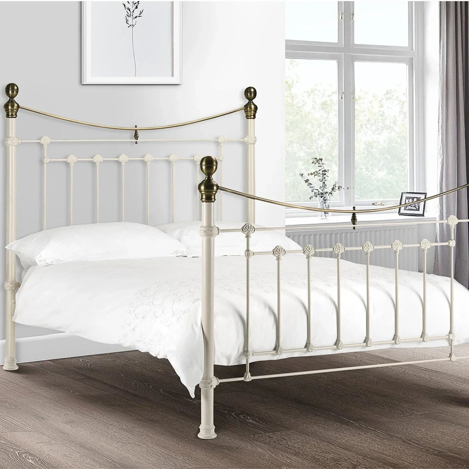 Stone white metal bed frame with brass accents in a bright bedroom setting