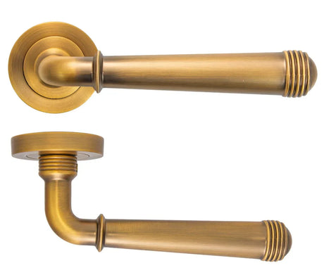 Antique brass door handle lever with round backplate and ribbed end detail