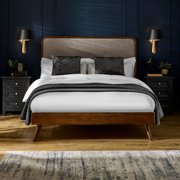 Walden bed with dark wood frame, beige upholstered headboard, white bedding, black pillows in navy room