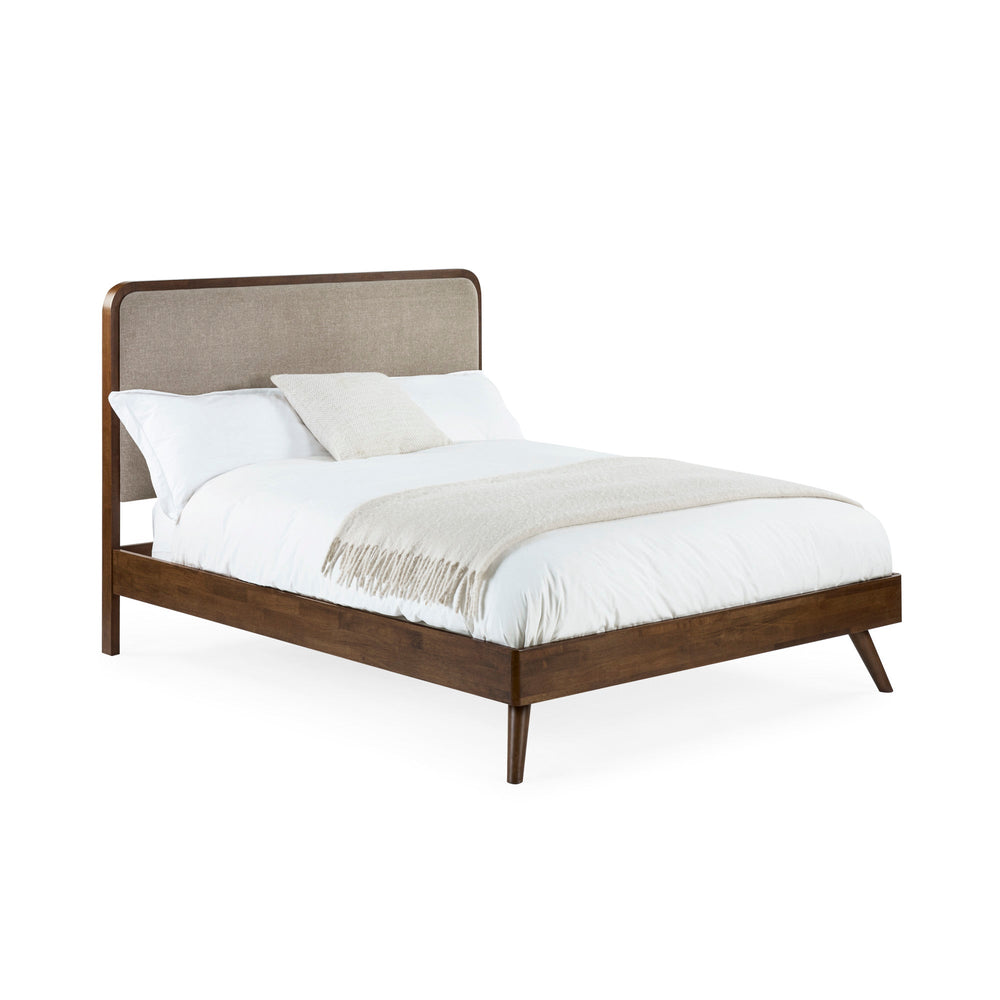 Walden bed fully assembled with white bedding, beige upholstered headboard, dark wood frame, angled side view