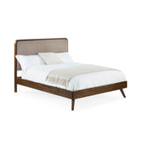 Walden bed fully assembled with white bedding, beige upholstered headboard, dark wood frame, angled side view