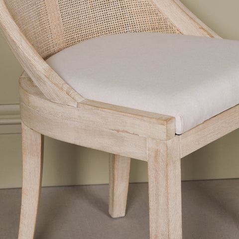 Light Wooden Sloped Rattan Upholstered Dining Chair with birch wood frame and linen seat in neutral tones