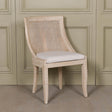 Light Wooden Sloped Rattan Upholstered Dining Chair with birch wood frame and linen seat in neutral tones