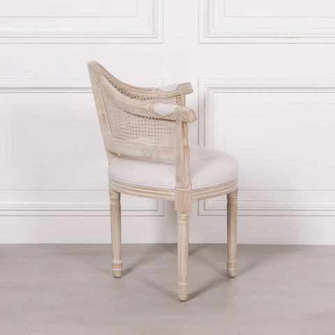 Light wood dining chair with round cushioned seat and rattan backrest