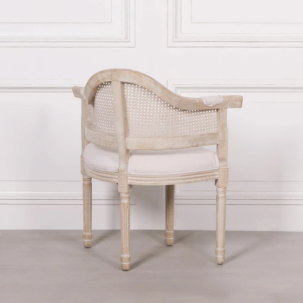 Round back cane accent chair with light wood frame and white upholstered seat, rear view