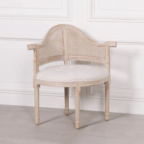 Wooden corner chair with cane backrest and white cushioned seat against panelled wall