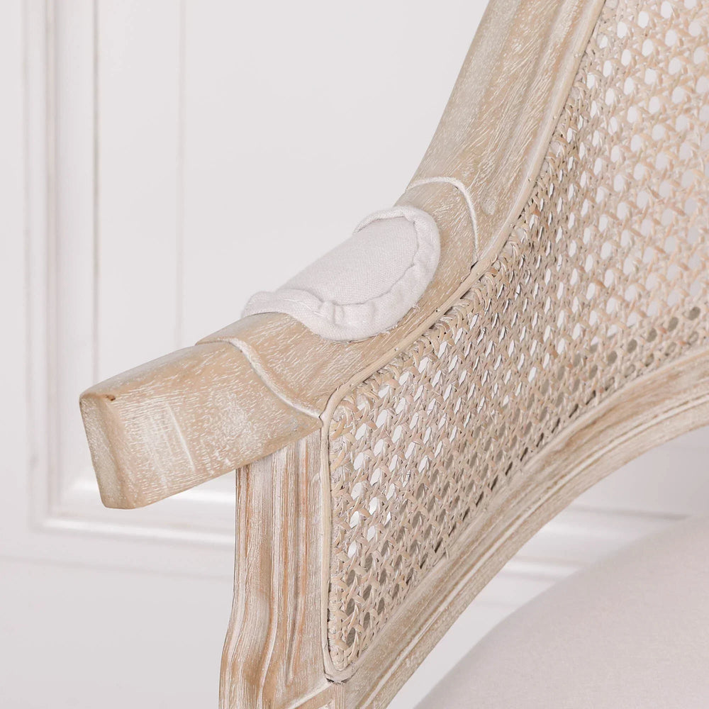Close view of rattan armchair with light oak wood finish and cushioned armrest