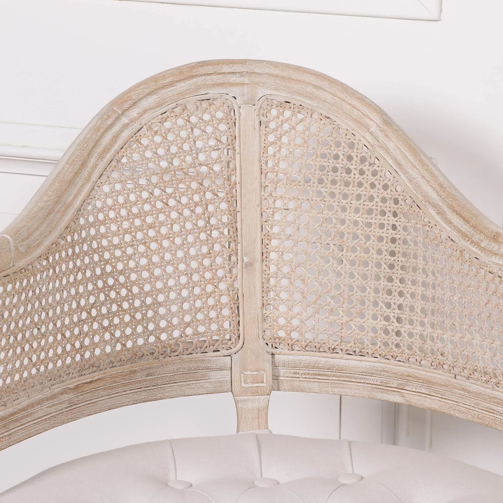 Light oak cane back dining chair with tufted cream seat close-up