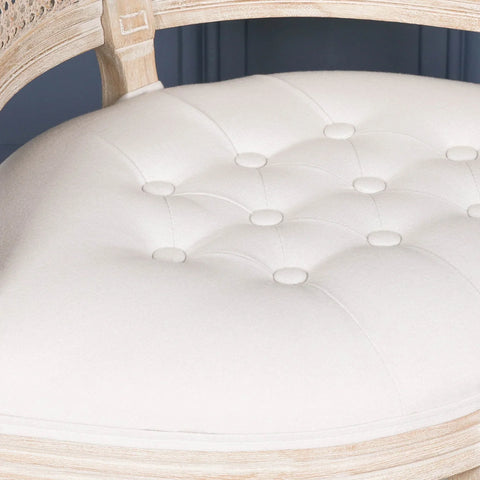 Tufted cream fabric chair seat with cane back and light wood frame closeup