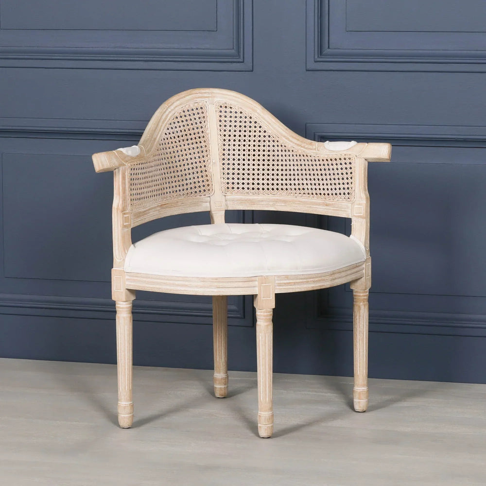 wooden cane-back occasional chair with white upholstered seat against blue panel wall