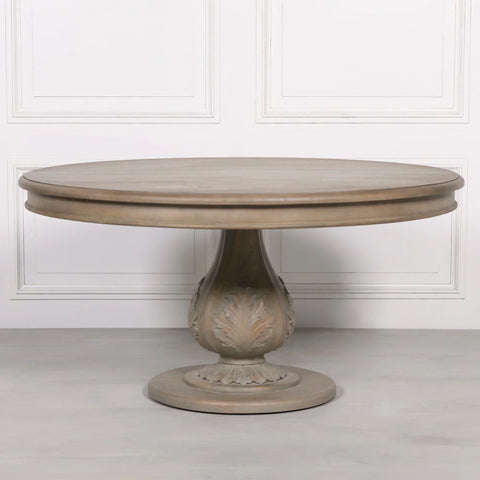 Round wooden dining table with carved pedestal base and light oak finish